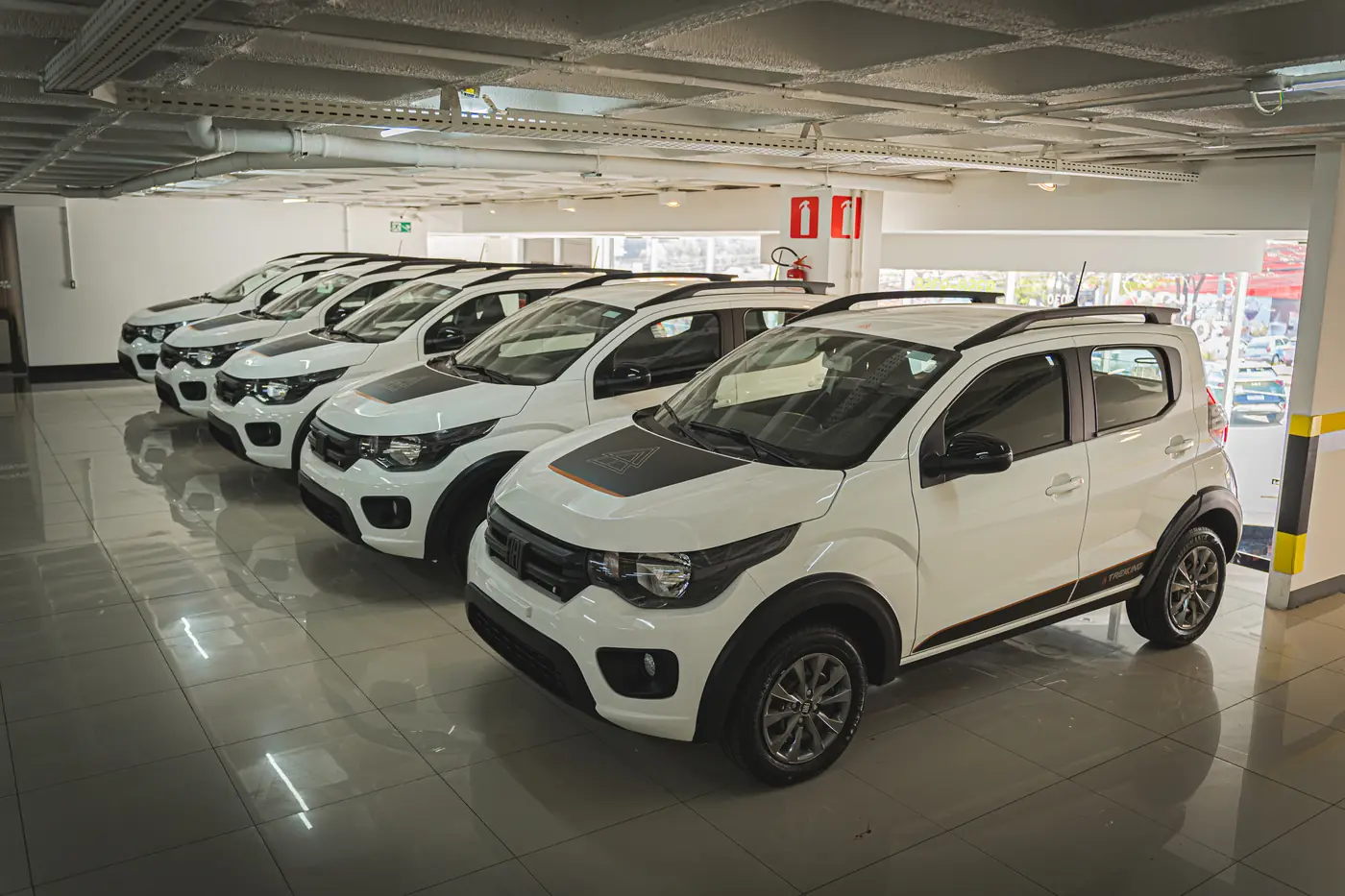 Fiat Mobi brancos enfileirados no pátio da AutoRede Locadora
