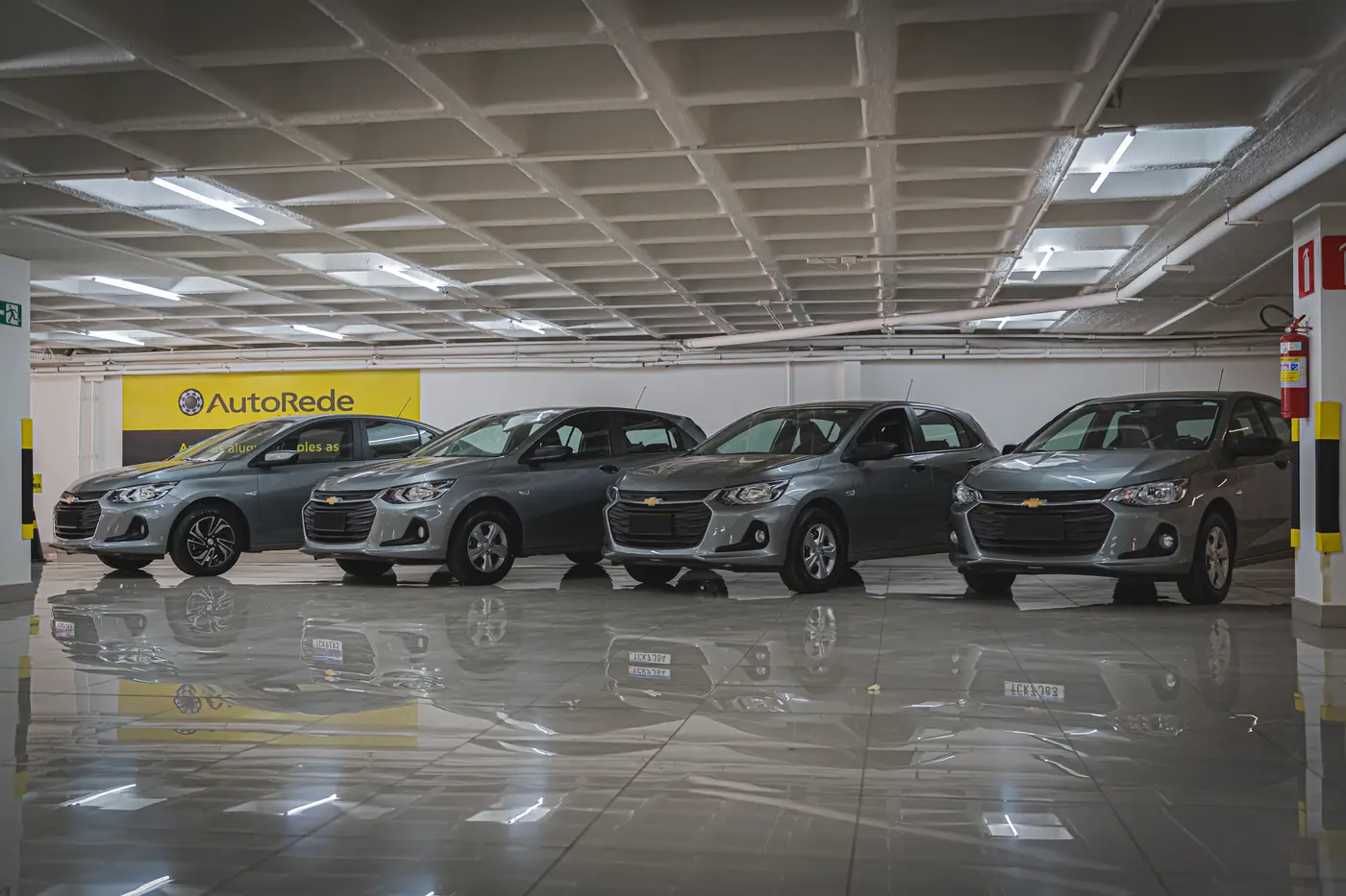 Chevrolet Onix da frota ao lado da sinalização da AutoRede